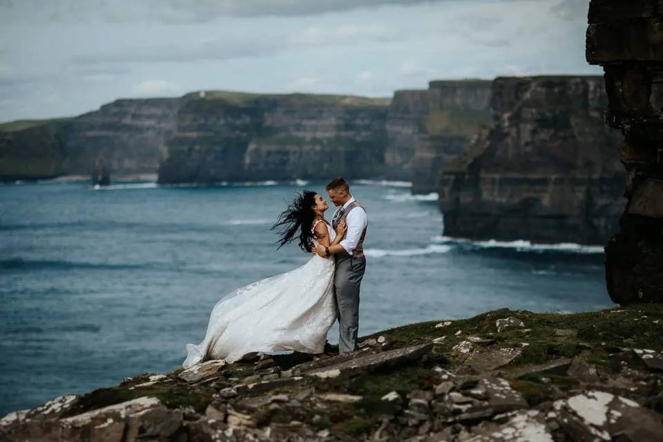 Newlyweds embrace on the Cliff of Moher