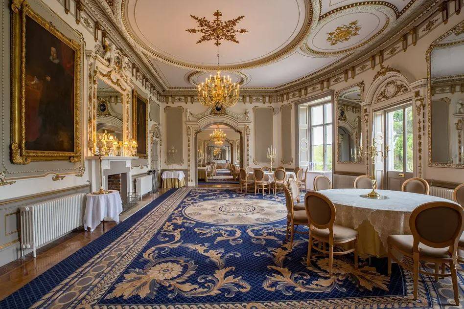 Dining room in a castle with antique furnishings and tables set for wedding guests