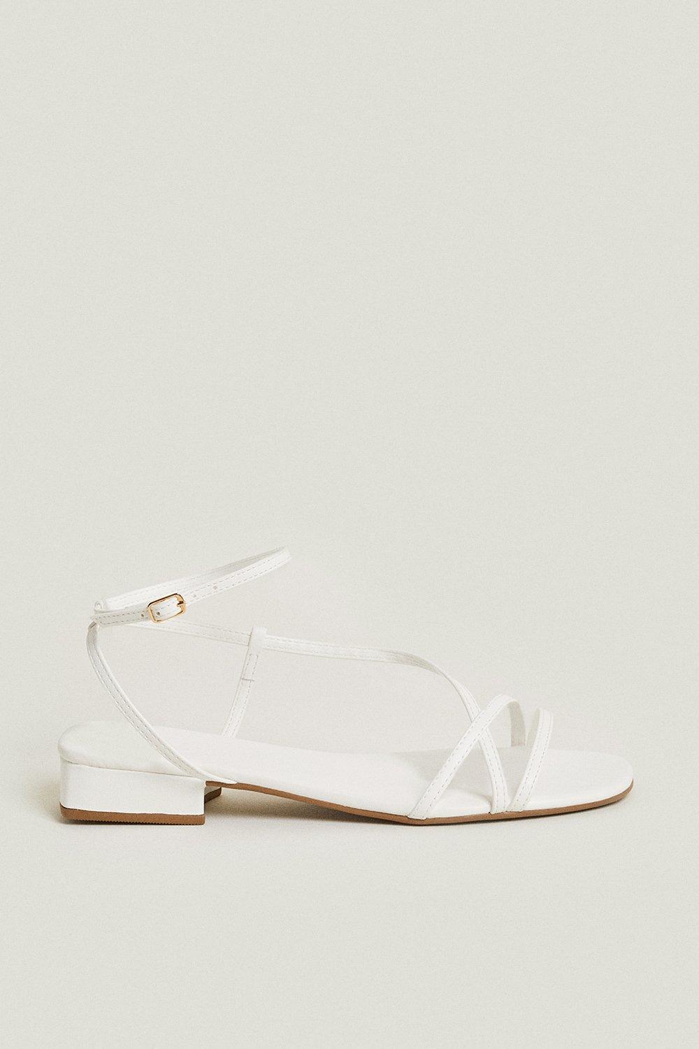 White simple sandal with an ankle strap and little gold buckle
