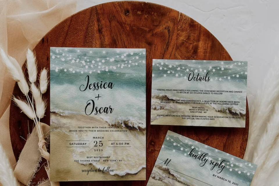 Image of a beach-themed wedding stationery suite on a circular piece of wood with a botanical arrangement