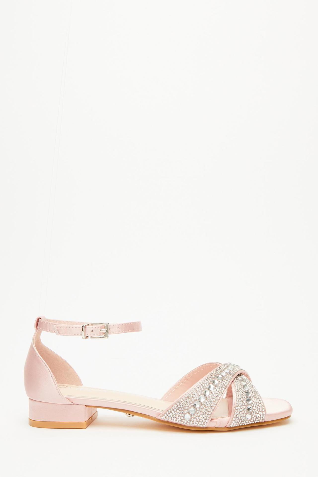 Light pink sandal with an ankle buckle strap and jewel details on the cross straps