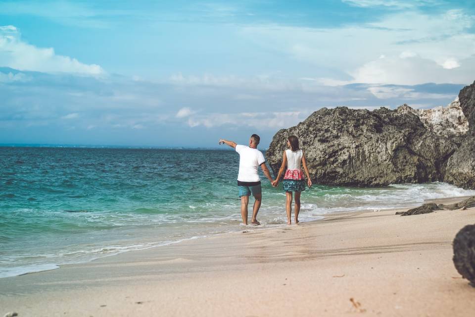 Couple walking along a beach, hand-in-hand