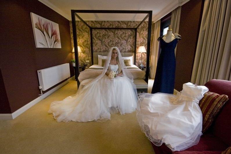 Bride in Bridal Suite With Dresses