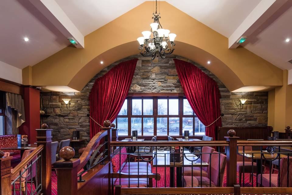 Stone walls, chandelier, and red drapes