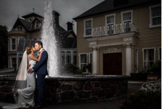 Newlyweds by the hotel fountain